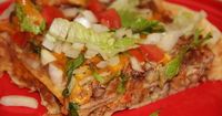 Tex-Mex Chalupa Casserole - A Tex-Mex casserole made from seasoned shredded pork, chicken or beef and beans, layered with corn tortillas, cheese and taco sauce and finished with chopped onion, tomato and shredded lettuce.