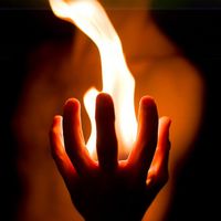 An aesthetic photograph of fire eminating from a hand.