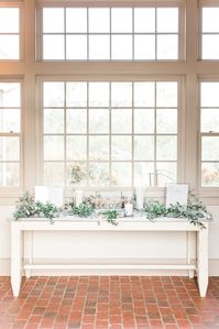 The first table your guests will see as they enter cocktail hour! This bride chose to accent with pillar candles and laid greenery. Venue: French Creek Golf Club