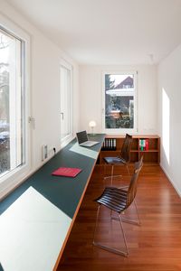 Contemporary Home Office by strauss architektin.  Long running desktop beneath windows.