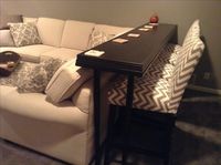 Bar Table behind sofa to allow more seating. Table top is black hardwood flooring trimmed with crown molding. I bought adjustable legs at IKEA and painted them black.