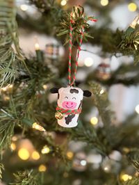 Meet Clarabelle Cow! This adorable Christmas tree ornament is made from recycled champagne corks and hand-painted for your holiday enjoyment. With her jingle bell collar and her love for spreading festive cheer, she’s ready to ring in the holidays with a moo and a twirl! Moooove over, Clarabelle's here!  Clarabelle Cow is a part of the Barnyard Creatures Collection. To purchase more than one creature at a discounted rate, visit our shop!