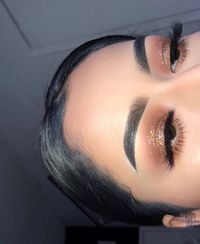 Smooth skin with clean brows and a bronzed shimmer eye and doll lashes.