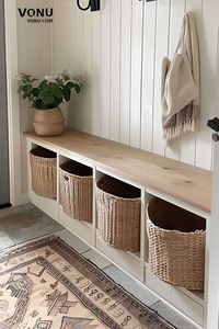 Maximize your entryway's functionality and style with this organized storage solution. Featuring a sleek wooden bench with built-in cubbies, perfect for storing baskets to keep your space clutter-free. The addition of a potted plant and a cozy hanging scarf adds a touch of warmth and personality. Ideal for busy households looking to keep their entryway tidy and inviting. Explore more tips and ideas to create a practical and stylish entry. #EntrywayDesign #HomeOrganization #EntrywayDecor #Functio