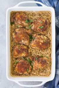 In this easy Baked Chicken and Rice Casserole, tender chicken thighs and rice cook together in one pan in the oven. Make it with brown rice or white rice, and bone in or boneless chicken thighs. One of our favorite healthy casserole recipes for a family dinner!