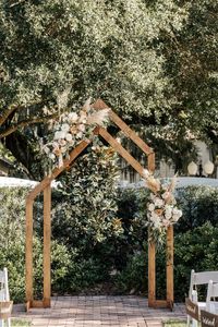 Stunning wedding arch adorned with beautiful floral arrangements. #weddingarch #woodenweddingarch #naturalweddinginspo #outdoorceremony #venue1902 #orlandoweddingvenue #centralfloridaweddingvenue 