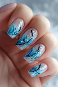 Breezy blue polish gradients are embellished with white fluffy cloud accents, silver feather details and rain droplets for a blustery spring nail look. #marchnails #springnails #bluenails #cloudnails #feathernails #nailart #naildesign