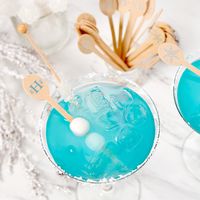 Blue winter cocktail with personalized drink stirrers