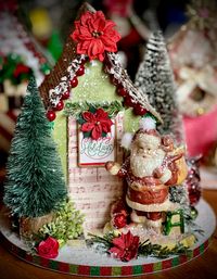 Pretty green Christmas glitter house with Santa. House is 8" tall on a 8" round base. Decoration only. Small parts. Choking hazard