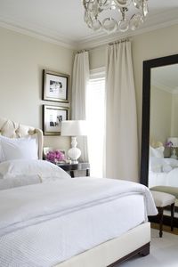 Guest Bedroom Inspiration. Neutral walls, white bedding, tufted headboard, dark wood accents.