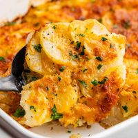 These cheesy scalloped potatoes have Parmesan baked in, a hint of nutmeg and garlic, and an optional layer of bubbly cheddar cheese.