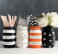 Set of four pint-sized mason jars painted and lightly distressed in painted pumpkin design, google eye, orange and white stripes and black and white stripes. Perfect for Halloween and fall décor to hold flowers or candles or candy. Great for Halloween party or Halloween gift idea. The insides of