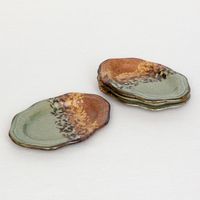 These little, oval plates are a perfect addition to the dinner table or stacked next to a platter for guests to use at your next party. In addition to the lovely hand-glazed patterning, these plates feature charming stamps reminiscent of stars or flowers.