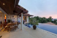 Outdoor dining table for six beside the blue-tiled infinity pool with sea views