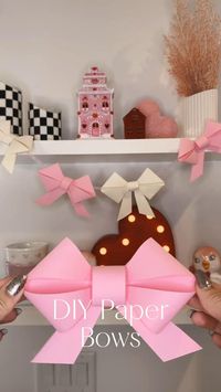 DIY Paper Bows 🎀🎀 -So our whole family got hit with a nasty bug. I havent had a fever in years and Ive had one 🙈 so crazy!! But I did manage to get this post put together so I could share. As you can see I used this method to make a little garland for my shelves! I made those bows a little bit smaller. These also look super cute on a tablescape, gift box, birthday parties, etc.. These are also easy, easy! If you follow the steps, it’s pretty hard to mess up! *P.S. use cardstock paper for these! They won’t look as cute if you dont! 🎀 LTK links in bio!