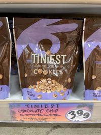 bag of Trader Joe's Tiniest Chocolate Chip Cookies on store shelf with sign $3.99