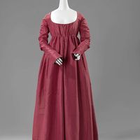 Gown, anonymous, c. 1790 - c. 1810 silk, l  At the end of the 18th century the wide skirts became narrower, and the waistline was raised to under the bosom. The narrow sleeves were so long that they extended to the middle of the hand. They were set in far at the back to a typical lozenge-shaped panel, the shape of which is emphasized by ornamental stitching in a colour that contrasts with the red silk of the dress. http://hdl.handle.net/10934/RM0001.COLLECT.51029