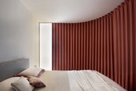 Red curved Dooor inside Milano Apartment