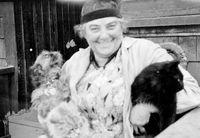 Emily Carr on the porch steps with her Brussels Griffon dog and black cat, 1930