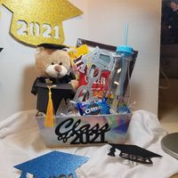 Graduation gift basket - This graduation gift basket can be given to anyone graduating on 2021. The gift basket consist of a 2021 gift box with the following items: - a graduation bear - 8 in - graduation novelty sun glasses (black, silver, pink, blue - please let me know your color preference) - a 5 x 7 picture frame to put your graduation picture in - a graduation water bottle - snacks - a graduation novelty box with treats The gift will come wrapped in cellophane paper tied with a bow. The gi