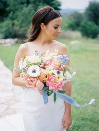 Their ceremony in Horseshoe Bay, Texas provided a stunning backdrop overlooking a stunning view through floor-to-ceiling windows. It was filled with lush flowers such as delphinium, peony, garden roses, and more! Stunning bride, Darci, was a vision with her spring, garden-inspired bridal bouquet. Filled with fluffy blooms with anemones, pink coral charm peony, garden roses, yellow butterfly ranunculus, blue delphinium; a vision in pastel spring blooms.