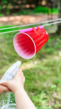 5.8K views · 1.5K reactions | This is a simple setup that’s easy for a camping trip, picnic, or backyard fun. My love using spray bottles and this is a great way to incorporate that resource:  Resources needed: A large straw 2 Cups String  Tape 2 spray bottles   Instructions: Loop and tie the string around 2 trees with the straws threaded on the string. Tape the cups to the bottom of the straws and line the cups up for a race. Make sure you change the setting on the bottle from mist to stream!  The benefits: Spray bottles can help build the tiny muscles in a child’s hands, much like scissor practice. Beyond the game, they are developing fine motor skills!  Save this simple idea to try later and follow along for more easy outdoor play ideas.   .⁣ .⁣ .⁣ .⁣ .⁣ #getoutside #outdoorlearning #pl