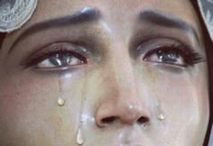 a woman with tears on her face and eye makeup is shown in this image