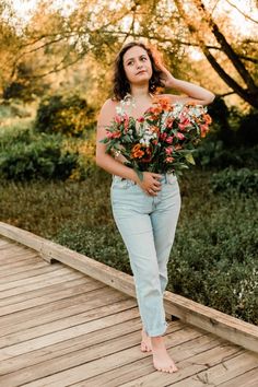 a woman standing on a dock holding flowers