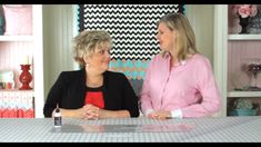 two women sitting at a table talking to each other