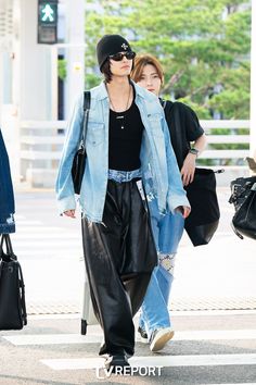 two people walking down the street with one carrying a handbag and another carrying a purse