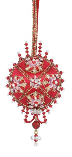 a red ornament hanging from the ceiling with beads and chains on it's sides