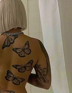 the back of a woman's body with butterflies tattooed on her upper half and bottom part