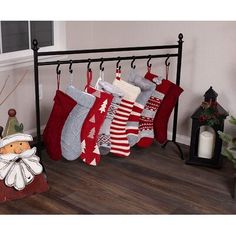 christmas stockings hanging from a rack in front of a window with candles and decorations on it