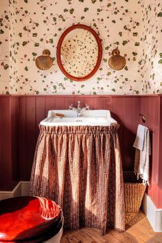 a sink and mirror in a room with floral wallpaper