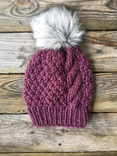 a knitted hat with a white and grey pom - pom on top