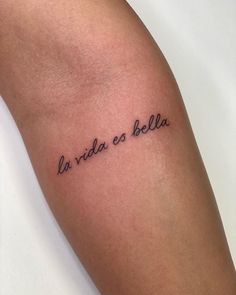 a woman's arm with the words la vida es bolla tattooed on it