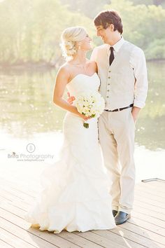 a bride and groom standing on a dock