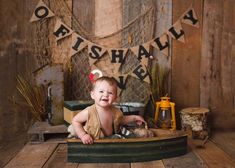 a baby is smiling while sitting in a wooden box with his feet on the ground