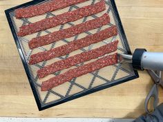 an american flag made out of hamburger patties on a cutting board with a hair dryer