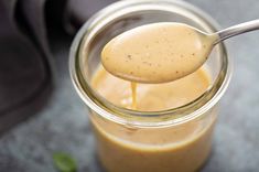 a spoon full of peanut butter sitting in a jar