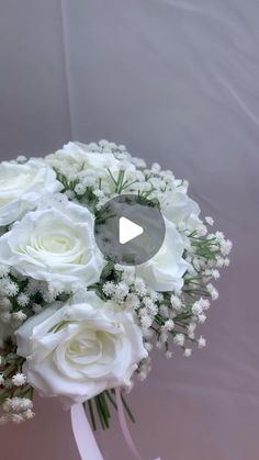 a wedding bouquet with white roses and baby's breath