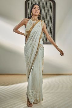 Ivory pre-draped saree with mild badla embroidery, contrast pipe and rope hand embroidered border
Components: 1
Pattern: Embellished, Hand Embroidery
Type Of Work: Rope, Pipe
Fabric: Chanderi
Color: Ivory
Other Details: 
Crochet flower embroidered hemline
Note: Blouse and belt worn by the model is not for sale
Occasion: Sangeet,Cocktail - Aza Fashions Traditional White Pre-draped Saree With Embroidered Border, Transitional Dola Silk Pre-draped Saree For Reception, Chanderi Pre-draped Saree With Zari Work For Reception, Festive Raw Silk Pre-draped Saree For Reception, Elegant Cotton Silk Pre-draped Saree With Embroidered Border, Off White Pre-draped Saree With Dupatta For Reception, Wedding Pre-draped Saree With Embroidered Border In Slub Silk, Off White Designer Pre-draped Saree For Festive Occasions, Festive Off White Pre-draped Saree