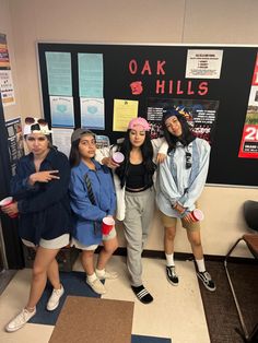 four girls posing in front of a bulletin board