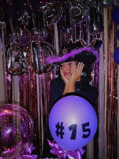 a woman is talking on her cell phone in front of balloons and streamers