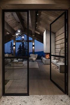 an open living room with glass doors leading to the outside area and fireplace in the center