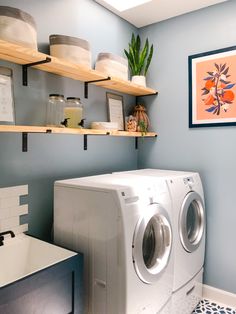 a washer and dryer in a small room with shelves above the washer