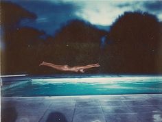 a person diving into a swimming pool at night