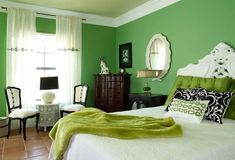 a bedroom with green walls and white furniture