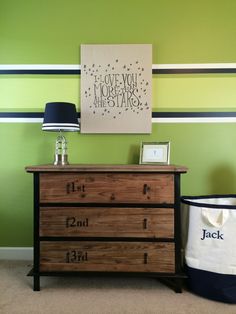 a dresser with two bins next to a green wall