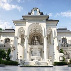 a large white building with a fountain in front of it